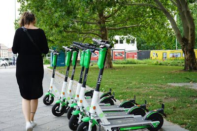 Woman walking by electric scooters in Milwaukee