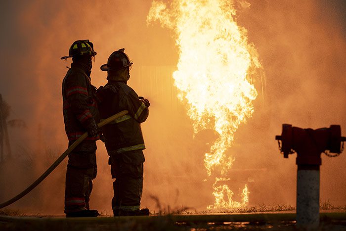 Firefighter team holding fire extinguishing representing The Wisconsin Alliance for Fire Safety